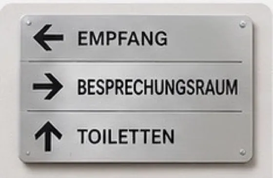 Wegweiser in Edelstahloptik mit Pfeilen zu Empfang, Besprechungsraum und Toiletten